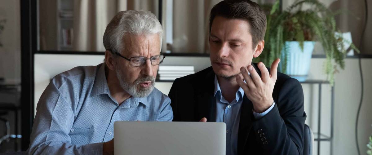 Two business men work at a computer