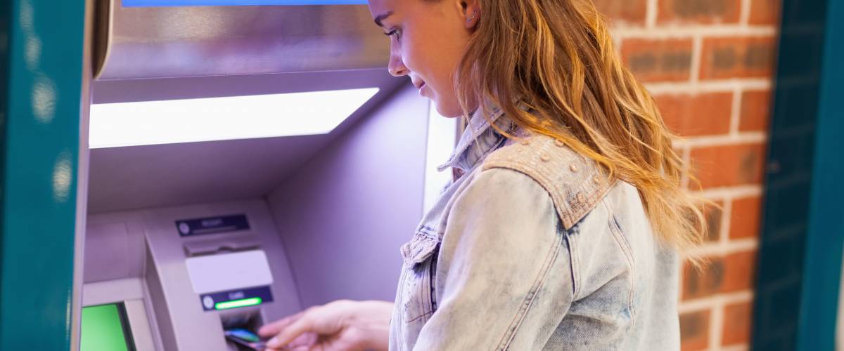 Image of woman at ATM using card.