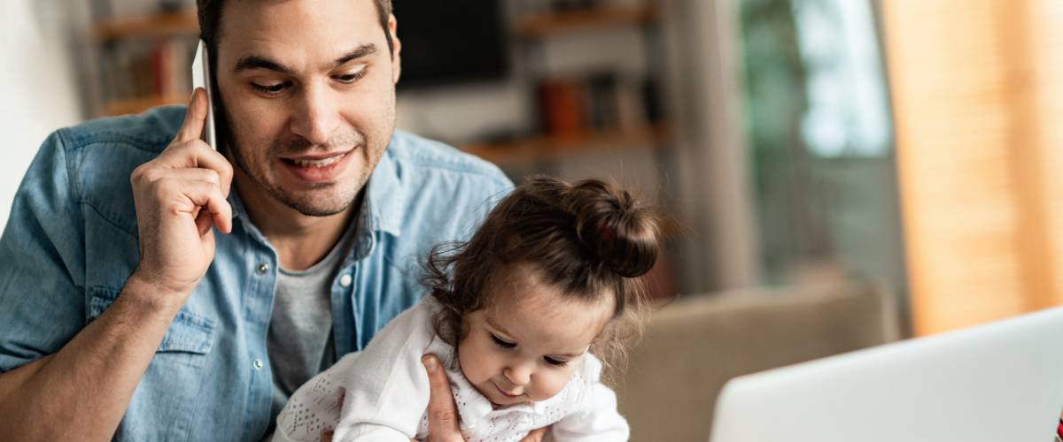 Image of man with baby and on the phone.