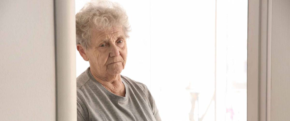 Senior woman counting coins at home. Poverty concept