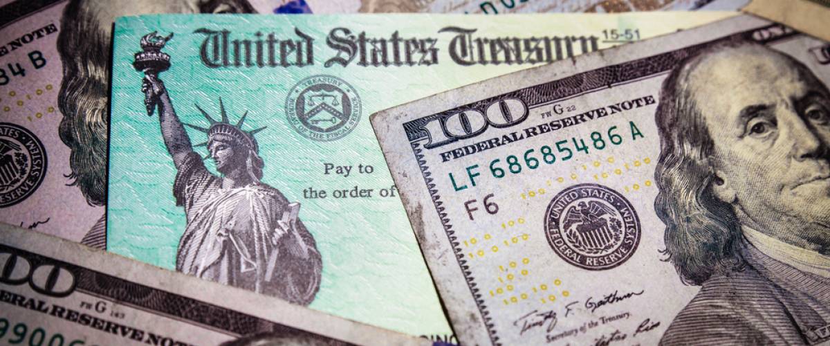 A U.S. Treasury stimulus check and $100 dollar bills
