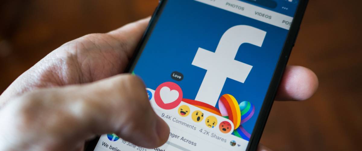 Facebook user touch on love button in Facebook application on iPhone 7.