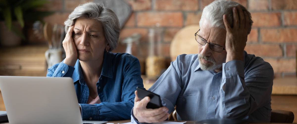 Unhappy mature couple checking documents and having problems