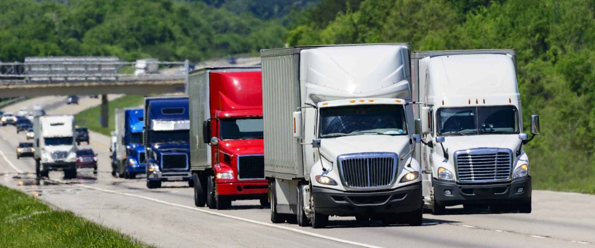 A squadron of eighteen-wheelers lead the way down an interstate highway in eastern Tennessee.