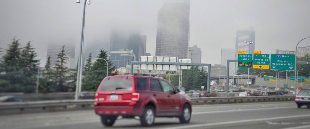 Foggy day in Seattle, skyscrapers, red car on front, city highway, high rises in fog, city views, city live ,