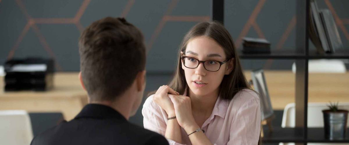 Confident millennial female applicant talking at job interview. How to find a recruiter.