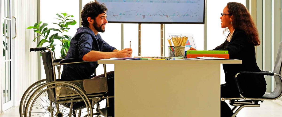 A woman is discussing with man in job interviewing for a handicapped person.