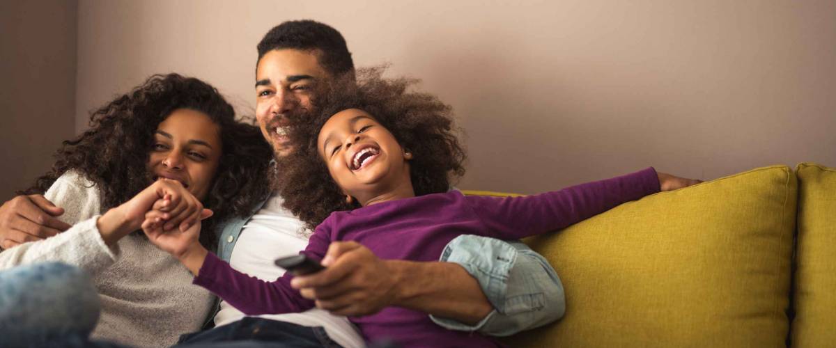 Mother, father and daughter having fun in the living room. Feeling happy and complete.