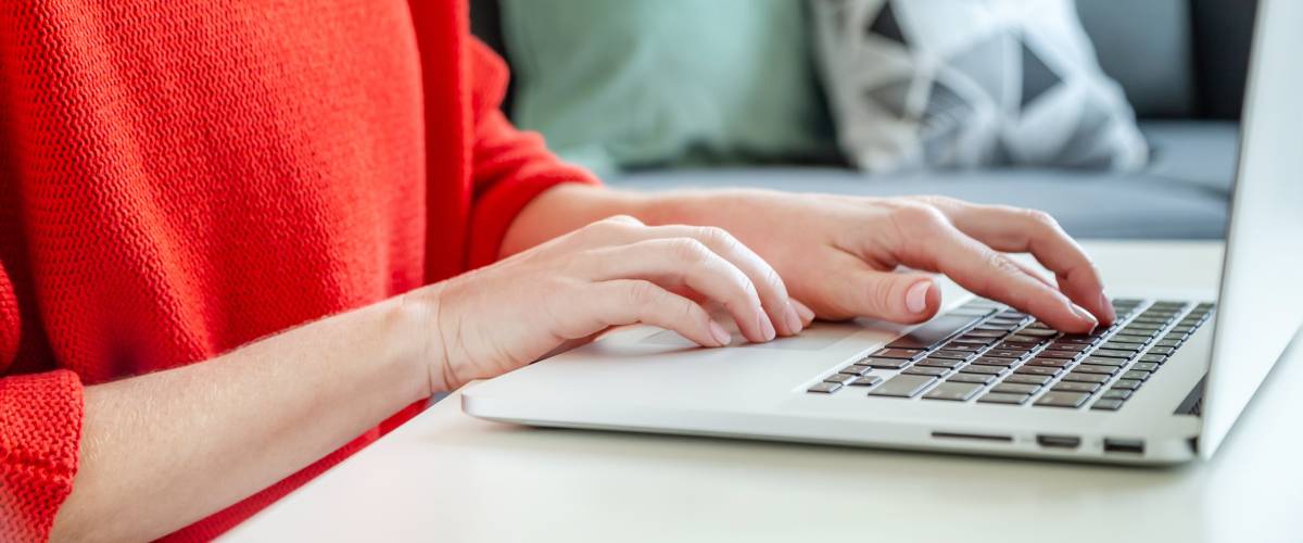 Woman in red sweater using laptop for job search