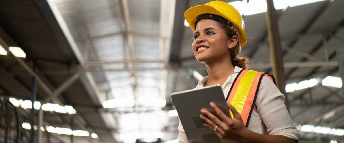 Portrait of industrial worker standing with tablet holding in her hand