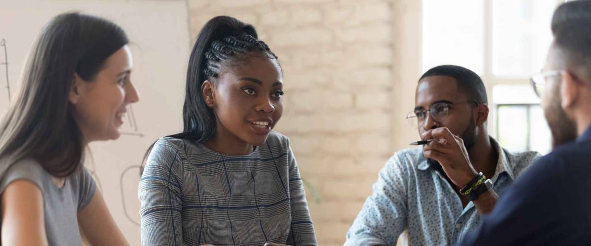 Multiracial millennial business partners talk at meeting in office
