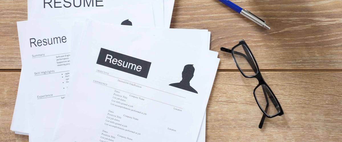 Resume applications on wooden desk ready to be reviewed