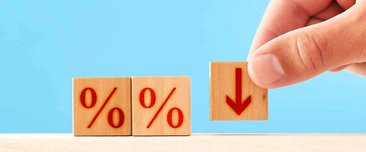 Percentage Down concept. man puts a wooden block with a down arrow next to blocks with percent symbols