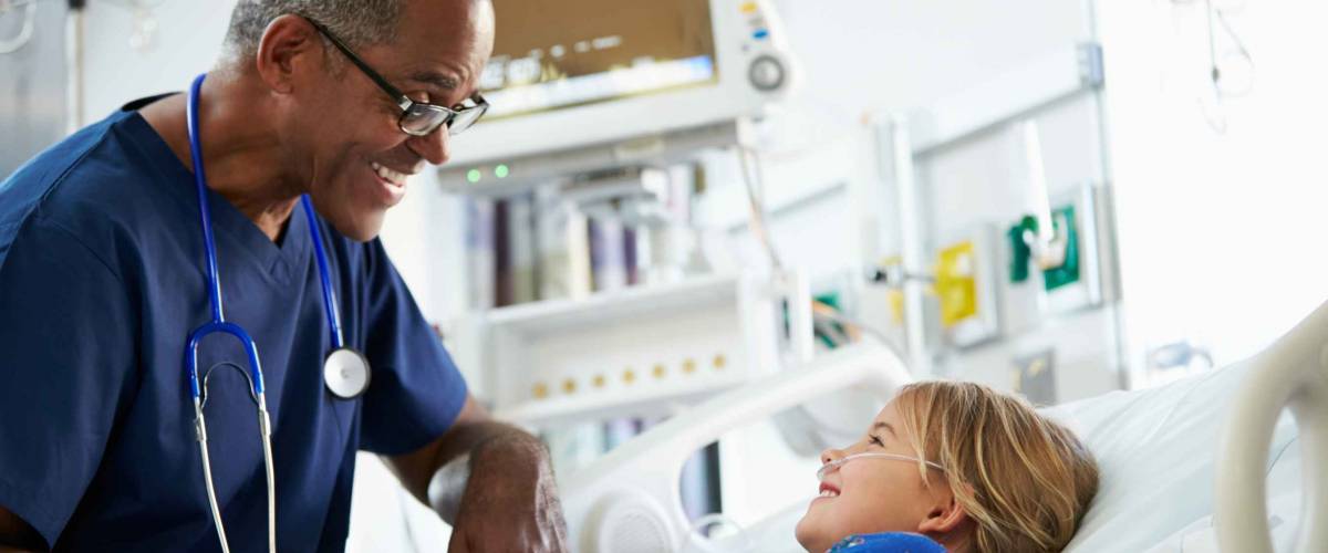 Young Girl Talking To Male Nurse In Intensive Care Unit