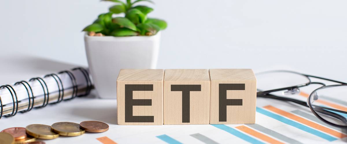 ETF word on wood blocks concept with chart, coins, notebook , glasses.