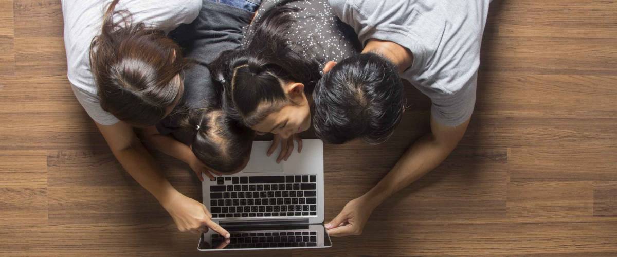Family top view lying on floor using laptop computer in her room at home