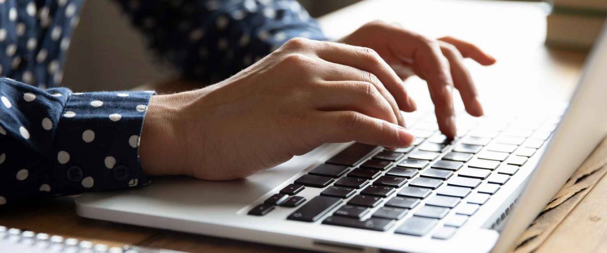 Close up image female hands typing on laptop keyboard.