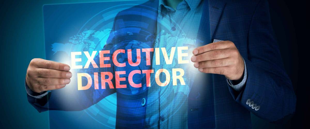 Businessman holding a transparent screen with an inscription a executive director. Business, technology, internet and networking concept.