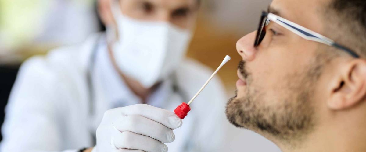 Close-up of young man getting PCR test at doctor's office during coronavirus epidemic.