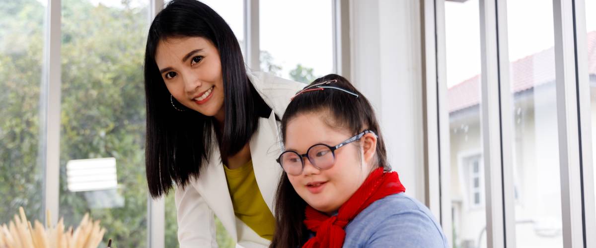 Teacher and girl with Down's syndrome in art class at school.