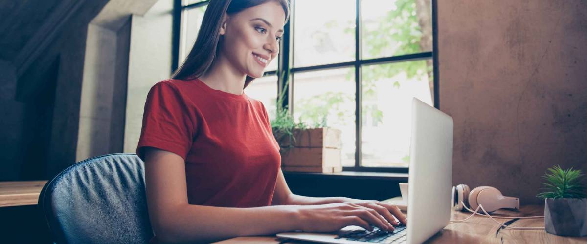 Young, business woman sitting in workstation, using portable computer device. Work in progress concept