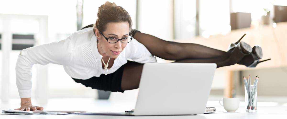 Smiling assistant doing yoga in office. She tired of sitting. Flexibility concept