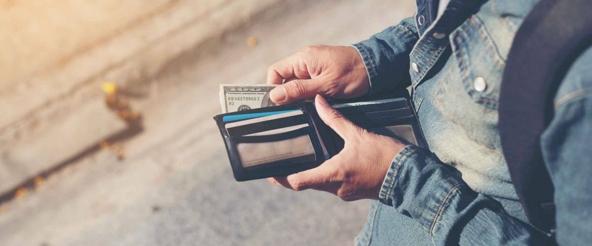 Hipster man hands holding wallet with credit cards and stack of money.