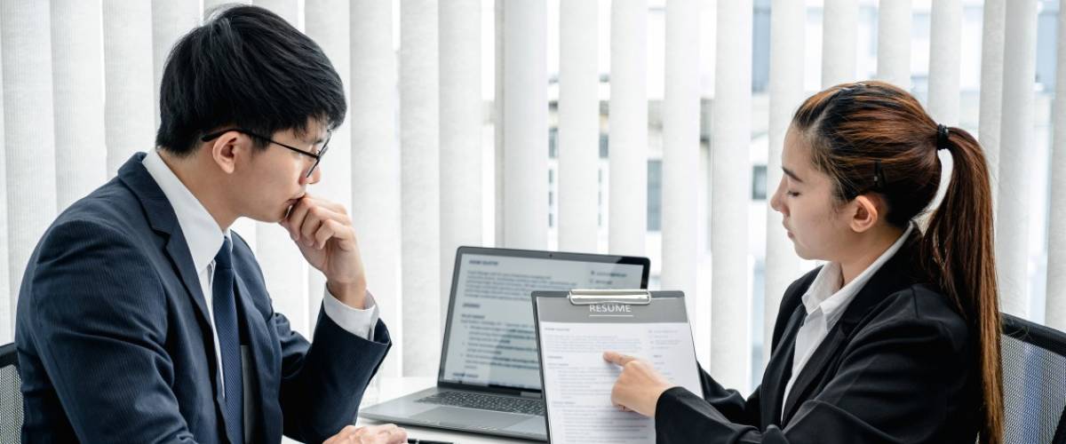Asian woman holding resume to explaining about her profile and past work experience to employer