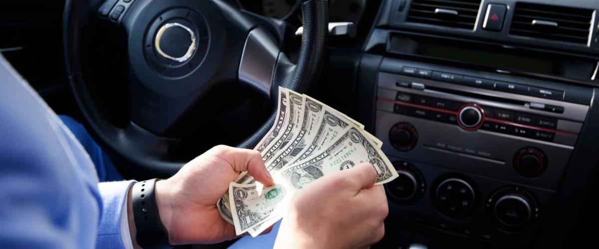Taxi driver gives change to a client. The payment in the taxi concept. Man calculates money in the car.