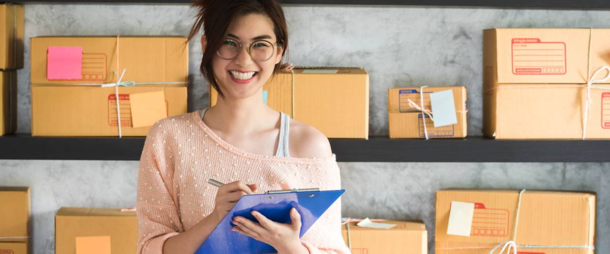 Teenage worker packing boxes to ship