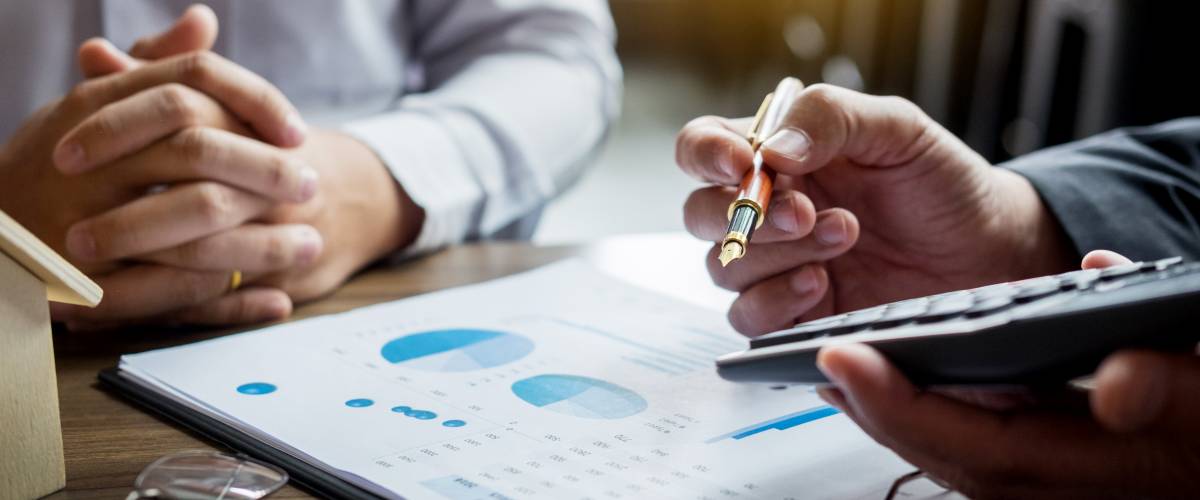 Agent holds calculator for present price for loan investment chart graph documents and calculating table payment to customer