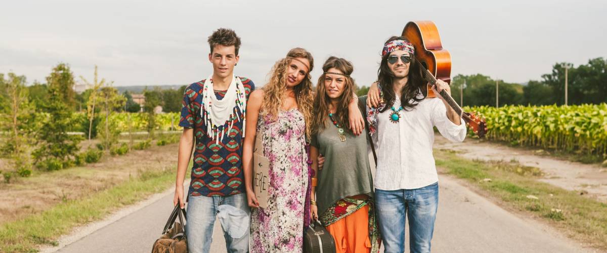 Four young adult hippie friends standing in the middle of a road