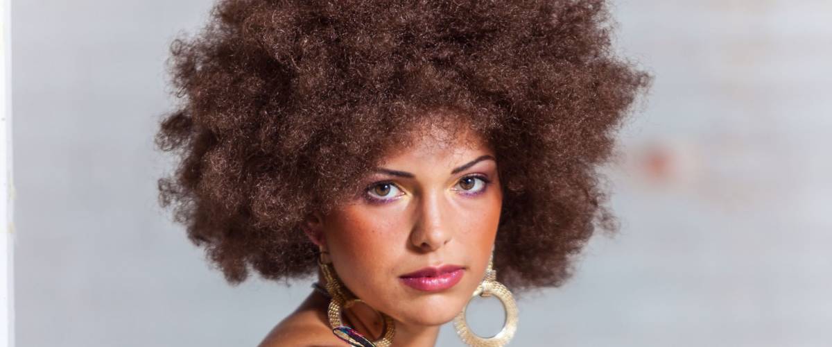 Portrait of woman with big hair wearing 1970s style clothing