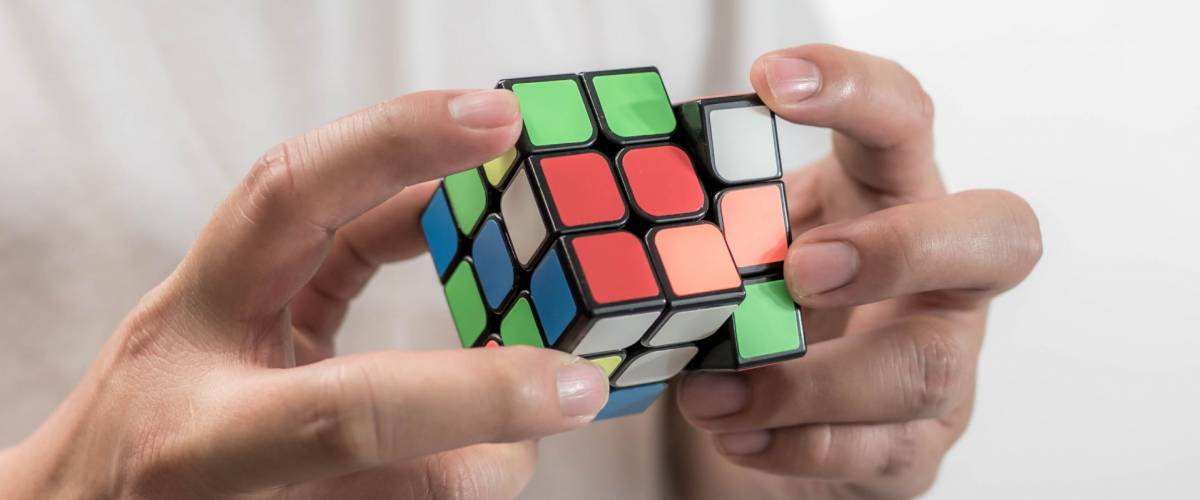 Bangkok, Thailand - July 19, 2018: Man wearing casual clothes collect Rubik's Cube. Rubik's cube invented by a Hungarian architect Erno Rubik in 1974.