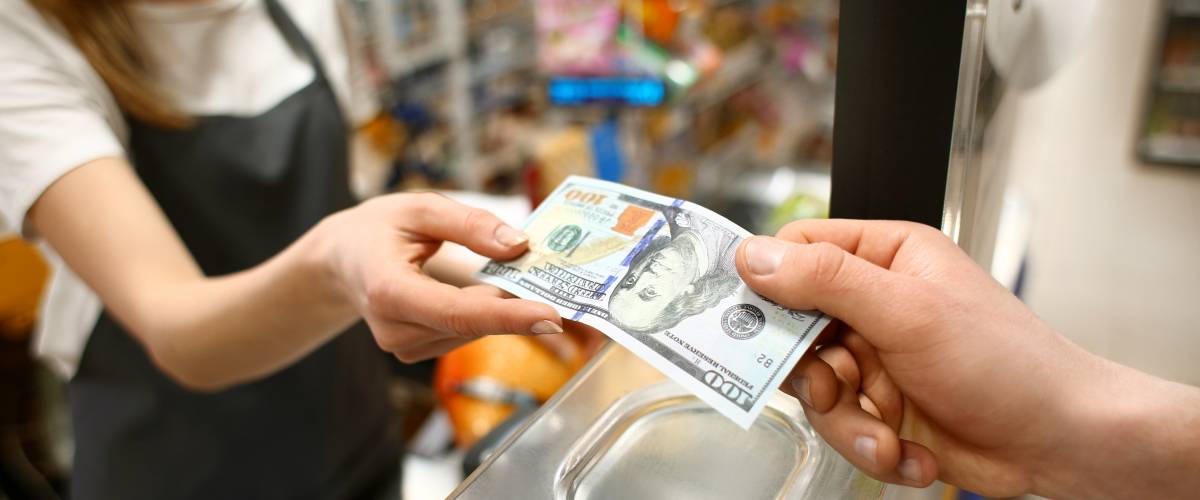 Young man paying for goods in supermarket, closeup
