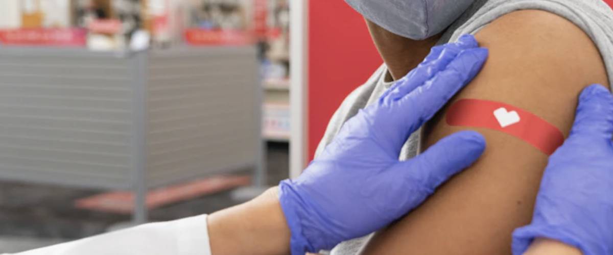 Pharmacist applying a band aid after flu shot