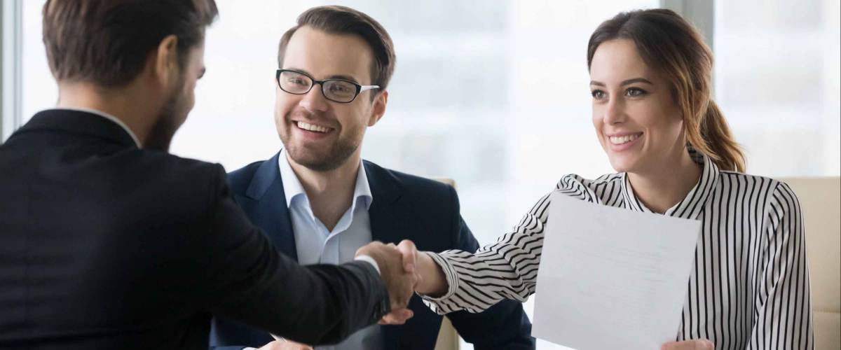 Happy employers shake hand of male job candidate. Successful good interview concept