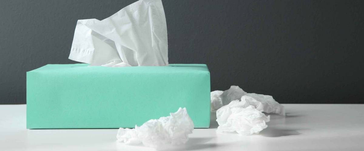 Used paper tissues and box on white table
