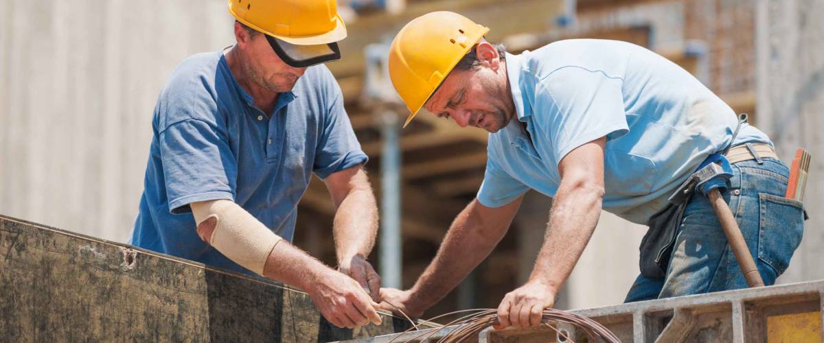 Construction workers collaborating in the installation of cement formwork frames