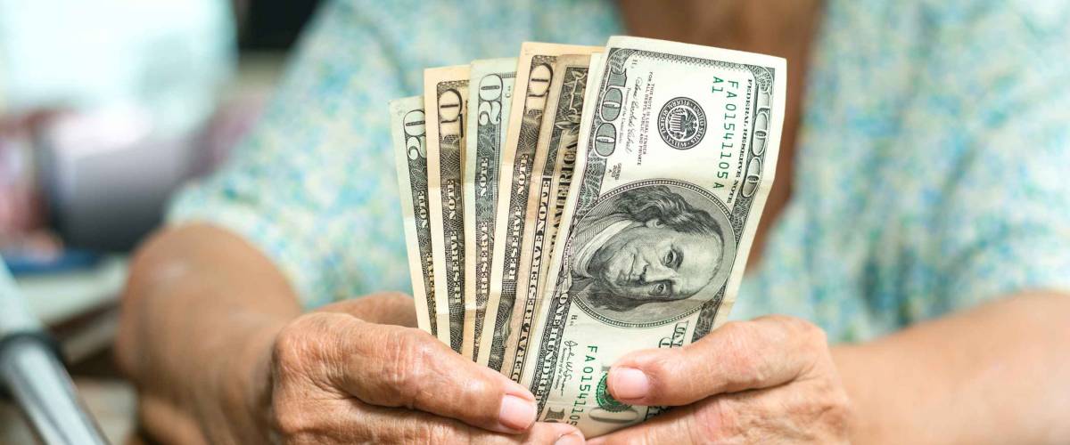 Elderly hands holding money. saving money concept