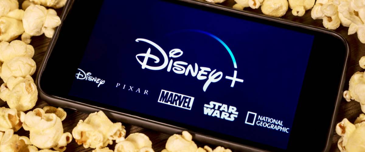 Disney Plus on smartphone with popcorn.