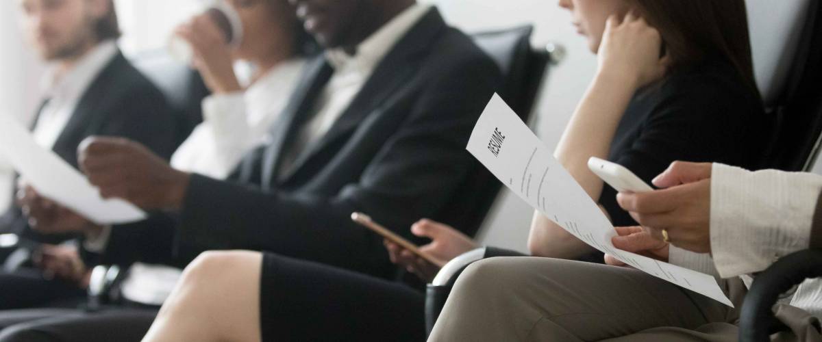 Horizontal side photo multinational applicants businesspeople sitting in queue waiting job interview holding resume papers