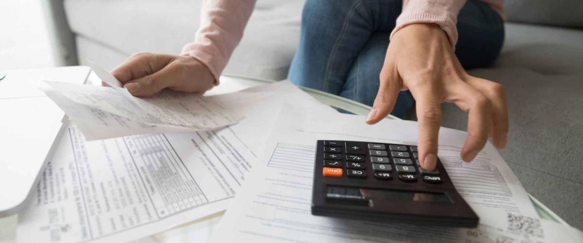 Female calculating expenses, close up view