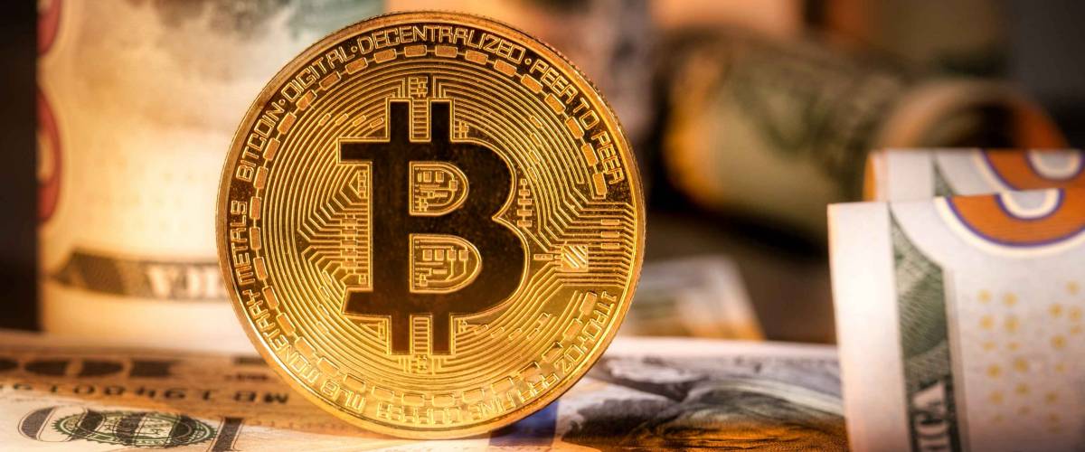 Close up of metal shiny bitcoin crypto currency coins on US dollar bills. Electronic decentralized money concept. Bitcoin is convenient payment in global economy market.