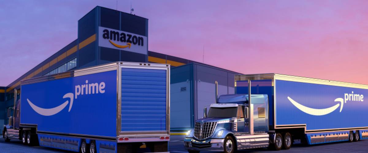 Tractor-trailers with the Prime logo parked outside an Amazon warehouse