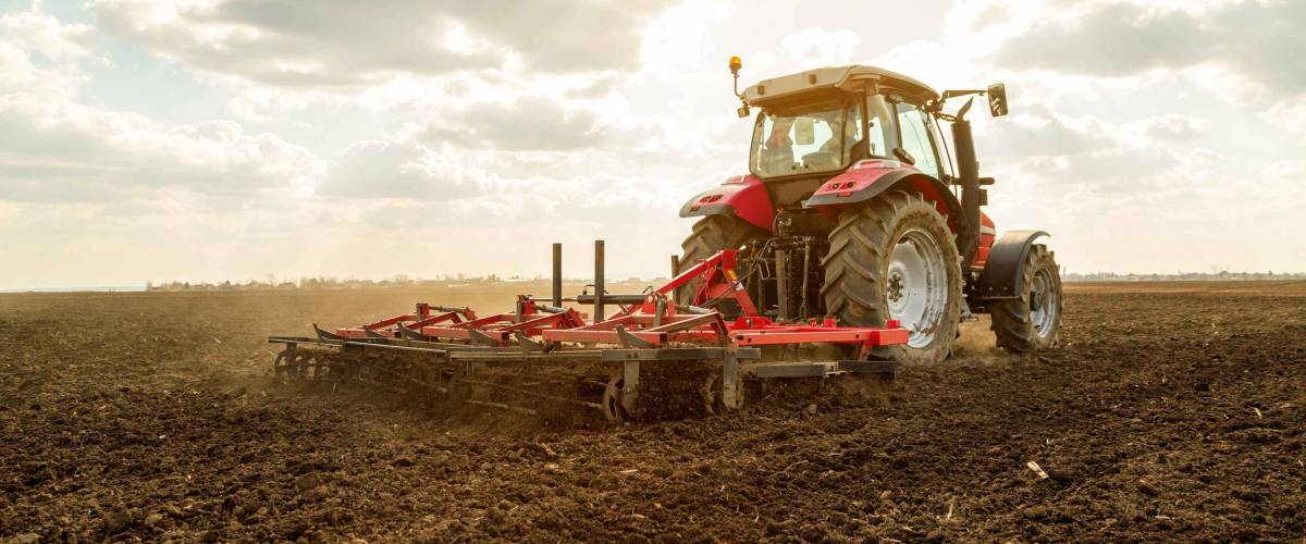 Farmer in tractor preparing land with seedbed cultivator