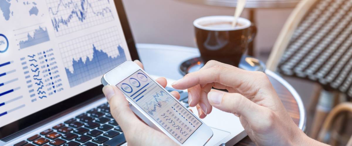 Close-up of hands of person analyzing stock market chart and key performance indicators