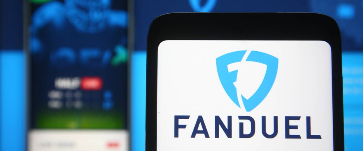 In this photo illustration FanDuel logo of a sports betting company is seen on a mobile phone screen in front of FanDuel website on background.