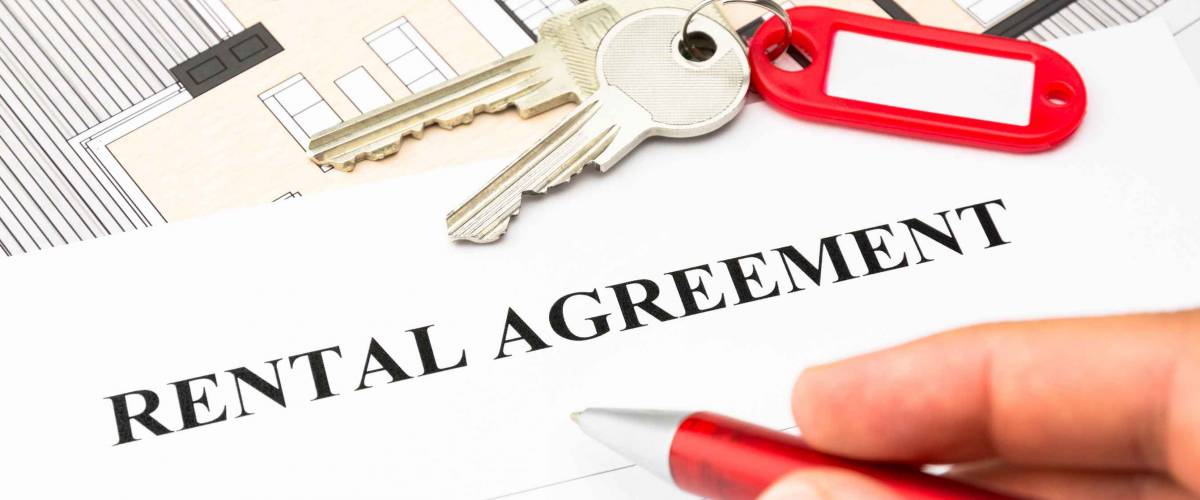 rental agreement contract with red pen and male hand and keys