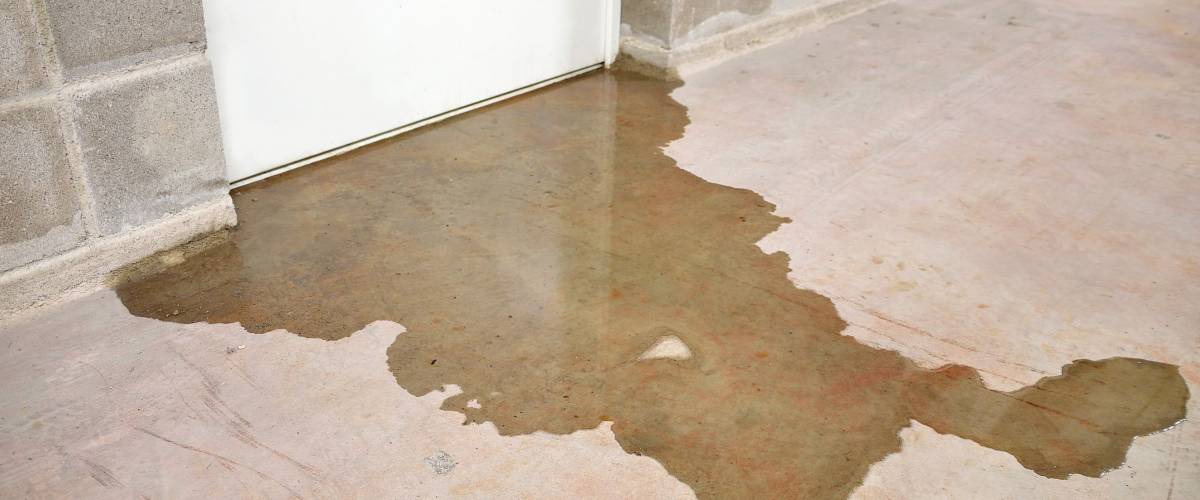 Water damage in basement caused by sewer backflow due to clogged sanitary drain